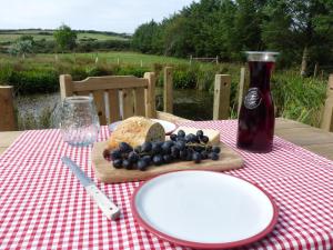 a table with a plate of bread and a bottle of soda at Shepherds Hut on Cornish Smallholding in Penzance