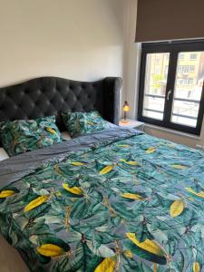 a bedroom with a bed with a colorful blanket at Charming duplex on the canal Brussels in Brussels