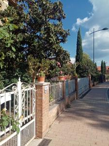 a white fence with potted plants on a sidewalk at Il Poggio in Murlo