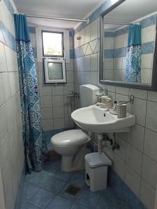 a bathroom with a sink and a toilet and a mirror at PENELOPE'S STREET OLD HOUSE in Lefkada +39 photos
