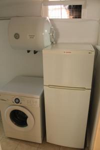 a laundry room with a washing machine and a washer at PENELOPE'S STREET OLD HOUSE in Lefkada