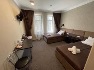 ein Hotelzimmer mit zwei Betten und einer Couch in der Unterkunft Khan Boutique Hotel in Almaty
