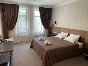 ein Schlafzimmer mit einem Bett, auf dem zwei Handtücher liegen in der Unterkunft Khan Boutique Hotel in Almaty