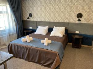 ein Hotelzimmer mit einem Bett mit Handtüchern darauf in der Unterkunft Khan Boutique Hotel in Almaty + 25 Fotos