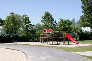 a playground with a red slide in a park at EuroParcs Molengroet in Noord-Scharwoude