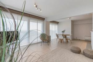 uma sala de estar com mesa e cadeiras em Gelijkvloers zeedijk appartement - lichtrijk en modern em Blankenberge