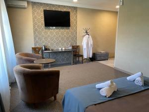 ein Hotelzimmer mit Bett und Fernseher in der Unterkunft Khan Boutique Hotel in Almaty