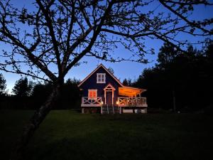 a small house with a light on the front of it at Święty Spokój Łąka i Woda in Pozezdrze