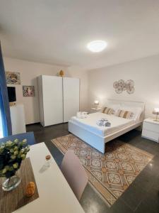 Un dormitorio con una gran cama blanca y una mesa. en Ostro - Guest House, en Agrigento