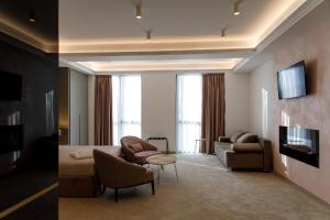 ストルミツァにあるHotel Eternoのソファと椅子とテレビのあるリビングルーム
