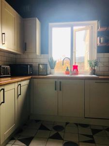 a kitchen with a sink and a window in it at Suffolk pink house, Newmarket town centre in Newmarket