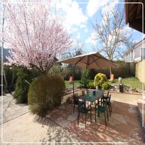 Saint-MauriceにあるVilla Maelio Jacuzzi Sauna et Salle de jeux - Privatifの傘とテーブルと椅子のあるパティオ