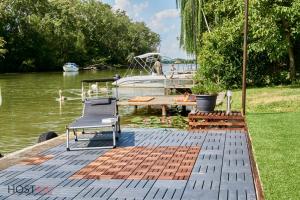 a dock with a table and a boat in the water at STÉG64 - Ráckeve - hostAID in Ráckeve