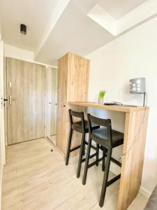 a kitchen with a table and a refrigerator at BP Apartment VI in Toruń