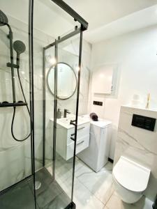 a bathroom with a toilet, sink, and shower stall at BP Apartment VI in Toruń