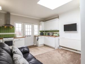 a living room with a couch and a kitchen at 493 Little Wakering Road in Southend-on-Sea