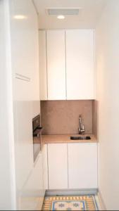 - une cuisine avec des placards blancs et un évier dans l'établissement Baixa Cosy Apartment, à Lisbonne