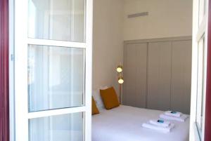 - une chambre avec un lit et un miroir dans l'établissement Baixa Cosy Apartment, à Lisbonne