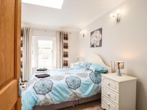 um quarto com uma cama azul e branca e uma janela em 493 Little Wakering Road em Southend-on-Sea