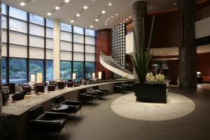 a lobby with chairs and tables and windows at Cerulean Tower Tokyu Hotel, A Pan Pacific Partner Hotel in Tokyo