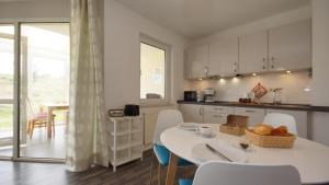 ロープベにあるFerienwohnung 4 im Strandhaus Lobbeのキッチン(白いテーブル、椅子、テーブル、椅子付) +10枚の写真