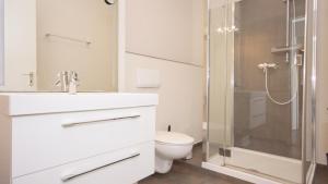 ロープベにあるFerienwohnung 4 im Strandhaus Lobbeのトイレとガラスのシャワー付きのバスルーム