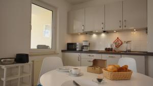 a kitchen with a table with a basket of bread on it at Ferienwohnung 4 im Strandhaus Lobbe in Lobbe