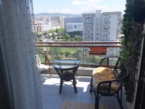 a balcony with two chairs and a table and a view at Sunny penthouse in Thessaloniki