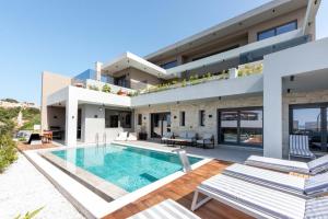 a villa with a swimming pool and a house at Seafront Villas I Luxury stay next to the sea in Chania Town