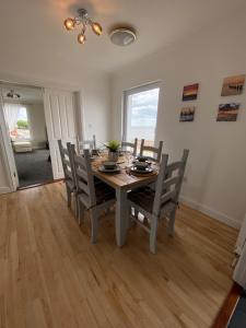 a dining room with a wooden table and chairs at Eastcliffe Penthouse, 2 beds & bathrooms with parking in Cleethorpes