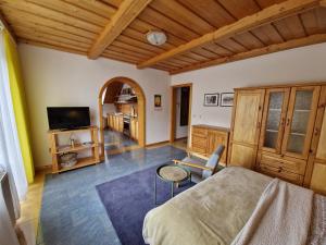 a bedroom with a bed and a table and a tv at Apartmány Skalka in Terchová