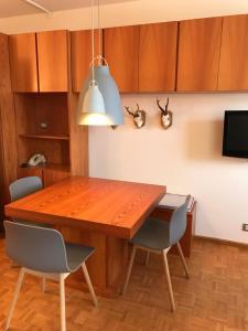 - une salle à manger avec une table et des chaises en bois dans l'établissement Appartamento con vista sull'Alpe di Siusi, à Bulla