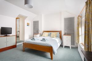 1 dormitorio con 1 cama y TV en Little Pengelly Farm, en Crowan