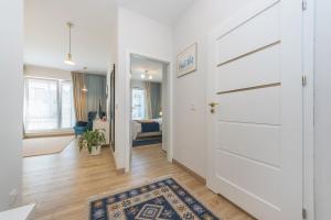 korytarz z białymi drzwiami i dywanem w obiekcie Abrahama Comfort Apartments w mieście Gdynia +8 zdjęć
