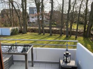 einen Balkon mit einer Bank und Parkblick in der Unterkunft Sand & Soul in Scharbeutz