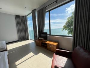 un soggiorno con TV e ampie finestre di Nancy Grand Osaky Condotel Vung Tau a Vung Tau