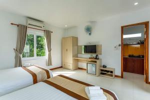 a hotel room with two beds and a kitchen at Mộc Lam Bungalow Phú Quốc in Phú Quốc