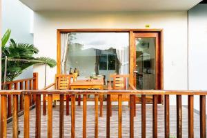富國的住宿－Mộc Lam Bungalow Phú Quốc，阳台配有桌椅和玻璃门。