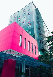 a large building with a pink building at Zuri Express Lippo Cikarang in Cikarang