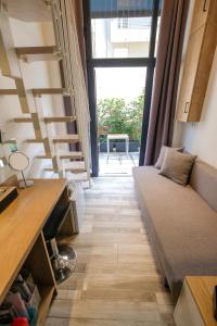 Una sala de estar con un sofá y una ventana grande. en BLACKHAUS YOUNG MINI, en Tesalónica