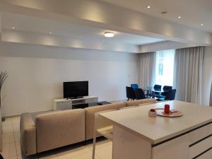 a living room with a couch and a flat screen tv at Ocean Suites Luxury Apartments in Protaras