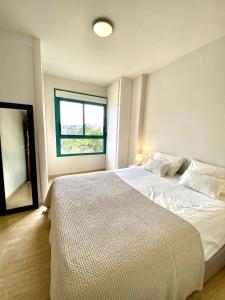 sypialnia z dużym białym łóżkiem i oknem w obiekcie Casa Toboso 2 w mieście Torre del Mar