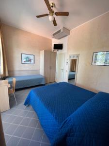a bedroom with a blue bed and a ceiling fan at Hotel Villa dei Fiori - sul mare con piscina in Rimini