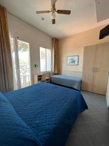 a bedroom with a blue bed and a window at Hotel Villa dei Fiori - sul mare con piscina in Rimini