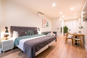 a bedroom with a large bed and a wooden floor at BILBAO RIVERSIDE by STAYNN APARTMENTS in Bilbao