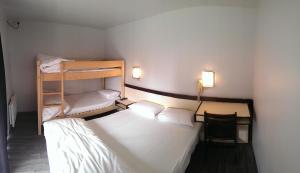 a small room with two bunk beds and a chair at Relais des 3 Pommes in Bayeux