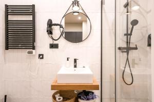 a bathroom with a sink and a shower with a mirror at BILBAO RIVERSIDE by STAYNN APARTMENTS in Bilbao