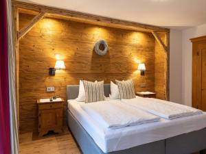 1 dormitorio con 1 cama grande y pared de madera en Sträublhof, en Wonneberg