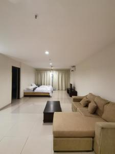 sala de estar amplia con sofá y cama en Spacious & Homey Apartment at Marina Island by JoMy Homestay en Lumut