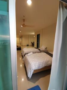 twee bedden in een kamer met uitzicht op de oceaan bij Spacious & Homey Apartment at Marina Island by JoMy Homestay in Lumut